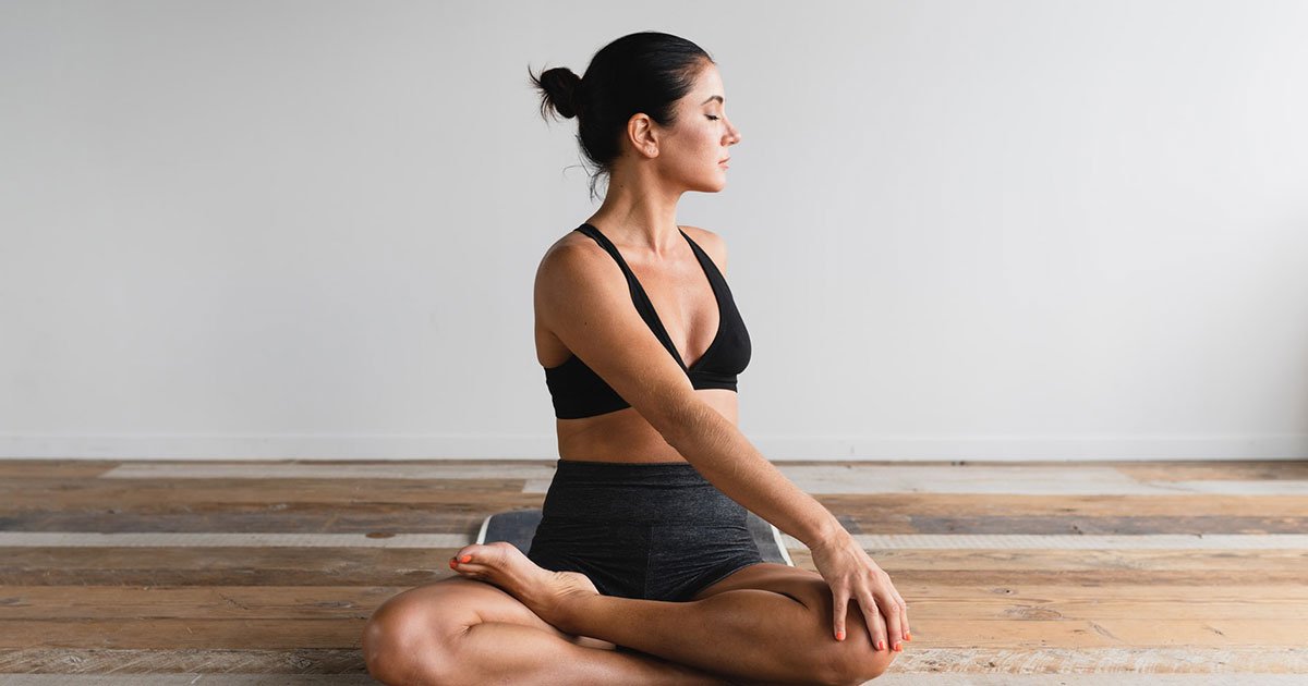 A person sitting calmly on the floor in a bright room