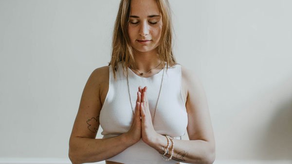 A person with hands together in a calm, mindful pause